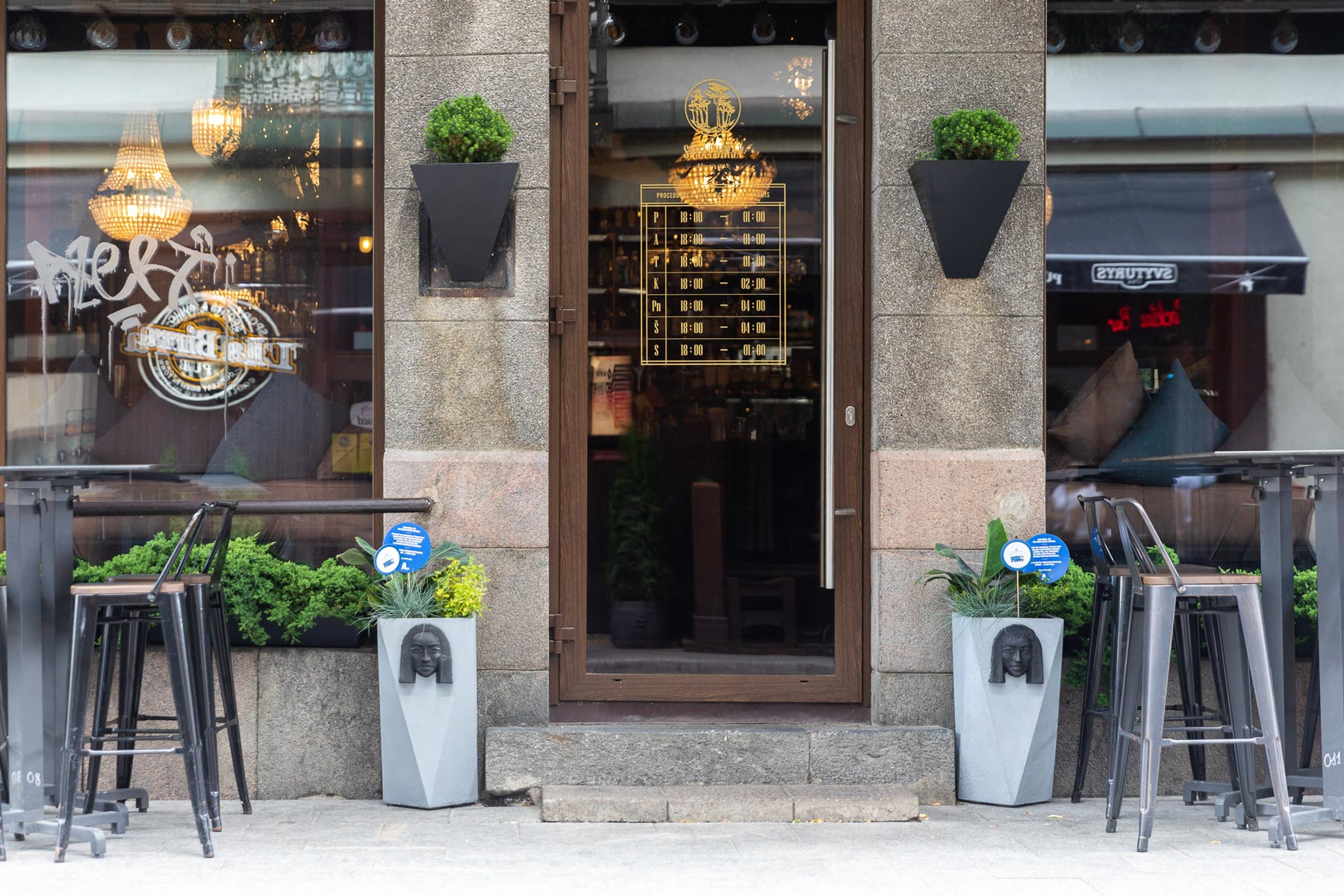 WASTE ART: women’s faces from plastic straws bar entrance with flower pots