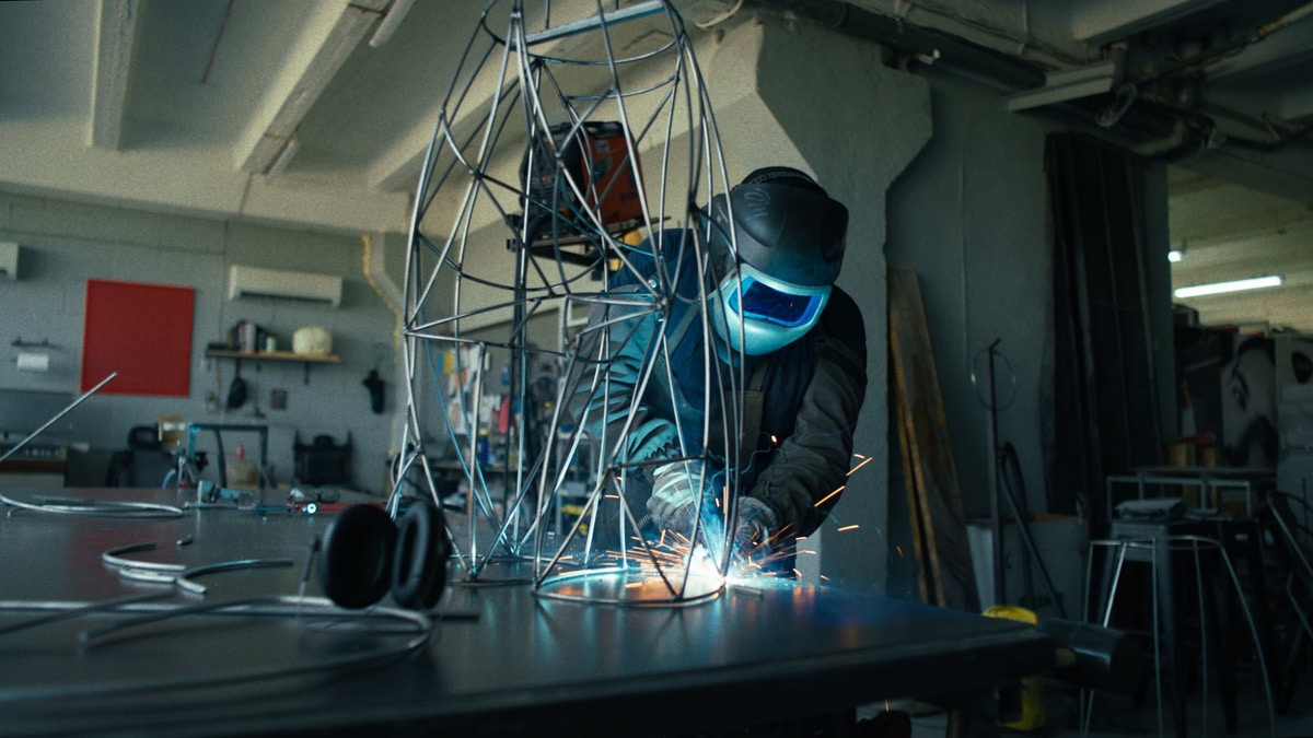 Metalworker welding the skeletal steel structure for the Adolescence art installation by Agne Kisonaite.