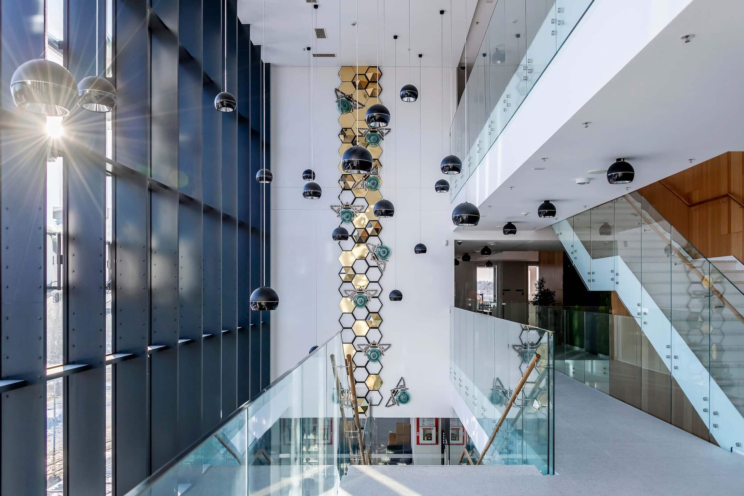 Full view of the Honeycomb upcycled art installation by Agne Kisonaite, featuring giant bees made from recycled electrical parts climbing a gold and aluminum structure.