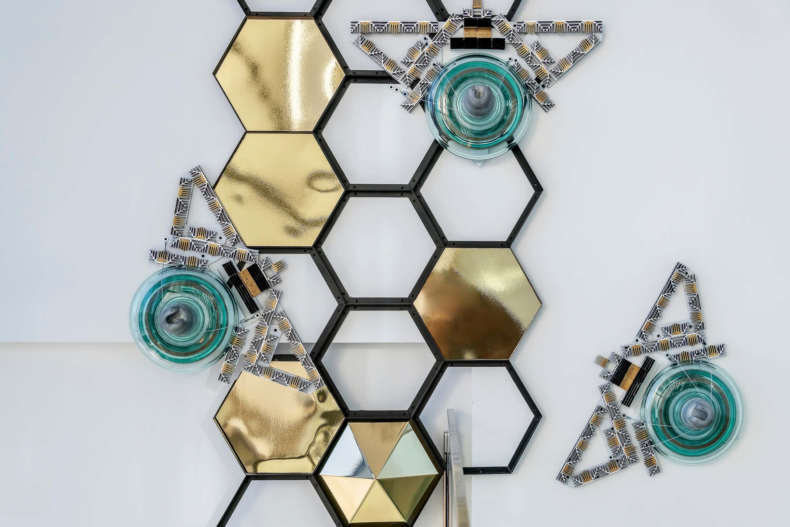 Close-up of a nearly nine meter-long bee sculpture crafted from striped high-voltage glass insulators and obsolete heaters, showcasing an Art Deco aesthetic.